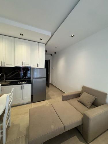 a living room with a couch and a kitchen at Deluxe Apartments Shengjin in Shëngjin