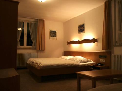 a small bedroom with a bed and a table at Hotel Gasthof Bären in Weingarten