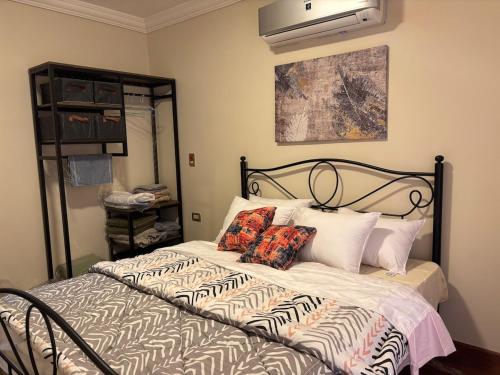 a bedroom with a bed with pillows on it at Makramia Condo in Madinaty in Madinaty