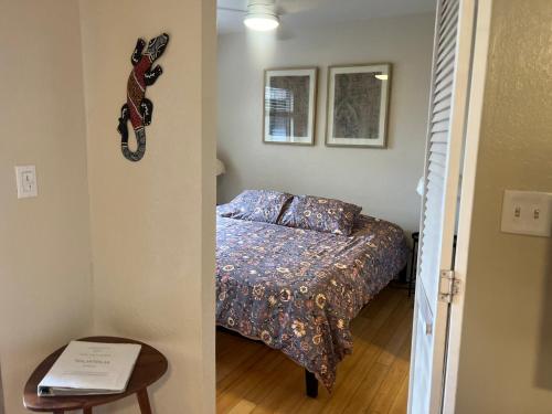 a small bedroom with a bed and a table at Beachfront 1 Bedroom Condo with Private Beach, Pool, Hot Tub in Pahala