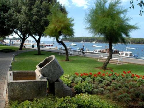 a park with a bench and some flowers and trees at Holiday apartment in Punat with swimming pool in Punat