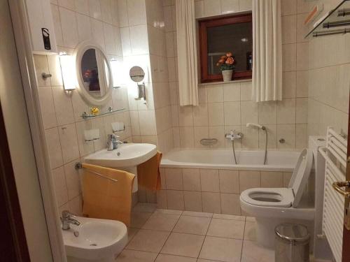 a bathroom with a sink and a toilet and a tub at Holiday apartment in Punat with swimming pool in Punat