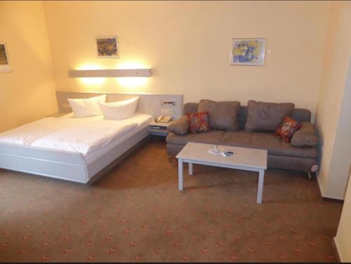 a hotel room with a bed and a couch at Hotel Gasthof Bären in Weingarten