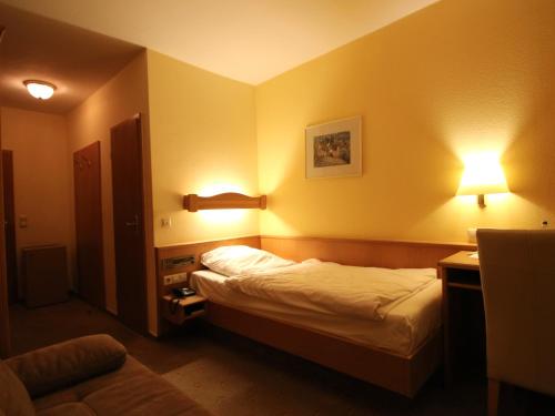 a hotel room with a bed and two lights at Hotel Gasthof Bären in Weingarten