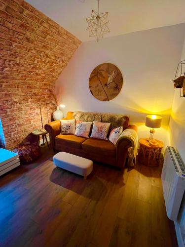 a living room with a couch and a brick wall at The Lodge Dunrowan in Kyle of Lochalsh