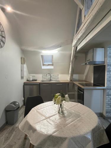 une cuisine avec une table avec un vase de fleurs dessus dans l'établissement Modern and bright studio, à Bourges