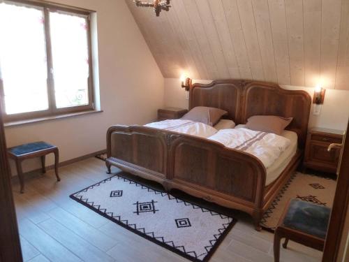 ein Schlafzimmer mit einem großen Holzbett in einem Zimmer in der Unterkunft Schiefferberg in Bernardvillé