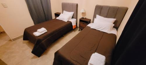 a hotel room with two beds and a table at Departamentos Tilcara in Tilcara