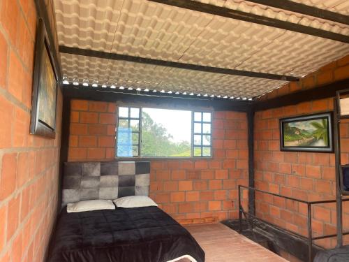 a room with a bed in a brick wall at Cabañas y Restaurante el Jardin in Murillo