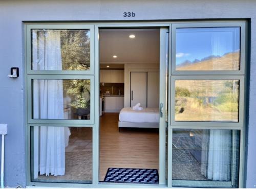 an open door to a bedroom with a bed at Unit With Kitchenette in Queenstown