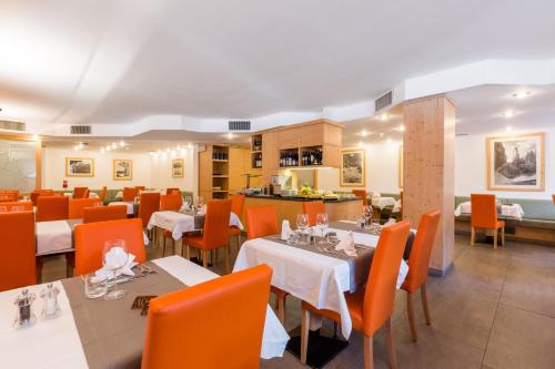 
a dining room table with chairs and a large window at Hotel Alpina in Madonna di Campiglio
