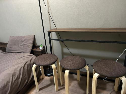ein Schlafzimmer mit zwei Hockern neben einem Bett in der Unterkunft Guest House Yakuin INN in Fukuoka