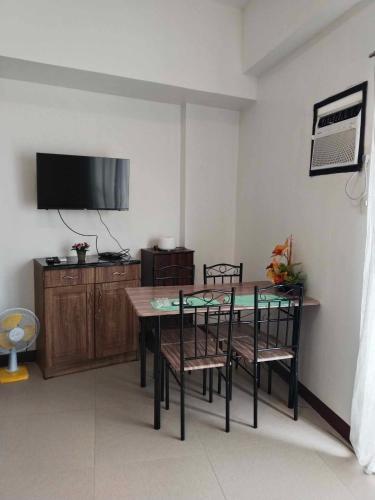 a dining room with a table and chairs and a tv at Perfect Budget Stay Near Airport in Pusok