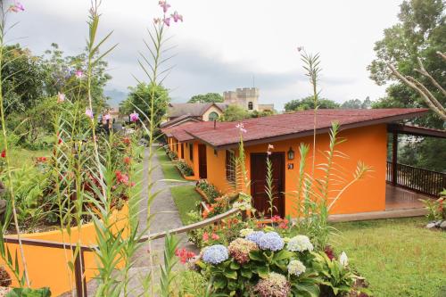 a house in a garden with flowers at El Santuario Ecolodge in Boquete