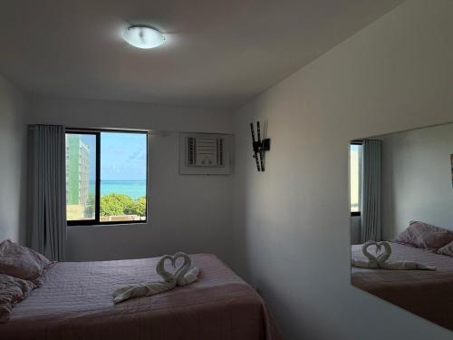 une chambre avec deux lits avec un miroir et une fenêtre dans l'établissement Apartamento Vista Mar, à Maceió