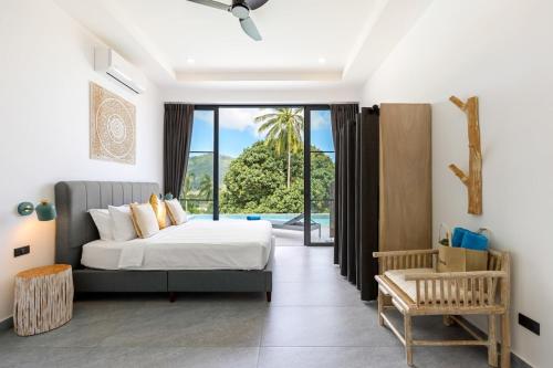a bedroom with a bed and a large window at VILLA CAMILLE - SEAVIEW - 4 Bedrooms in Koh Samui 