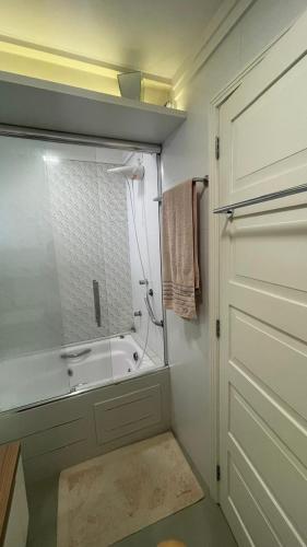 a bathroom with a shower and a sink and a door at Apto Charmoso Próximo à Catedral in Santa Cruz do Sul