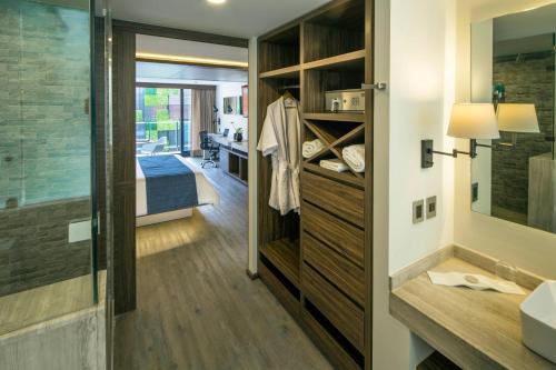 uma casa de banho com um lavatório e uma cama num quarto em FlowSuites Condesa - Adults Only em Cidade do México