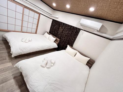 two beds in a small room with white sheets at Y-Shinjuku City, Okubo 5F-SJ0070 in Tokyo