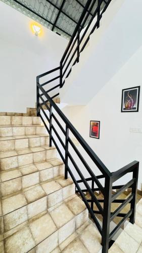 a staircase with black railings and white walls at mountain lake view private pool villa -Wayanad in Meppādi