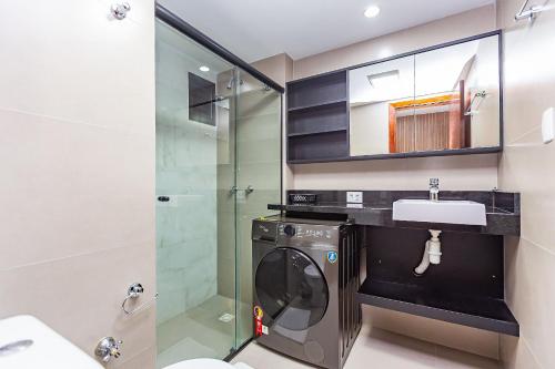 a bathroom with a washing machine and a sink at Apartamento incrível prox. shopping curitiba in Curitiba