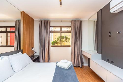 a bedroom with a white bed and a window at Apartamento incrível prox. shopping curitiba in Curitiba