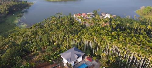 an aerial view of a house with an umbrella on a hill at mountain lake view private pool villa -Wayanad in Meppādi