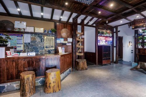 a restaurant with a counter and some wooden stools at 张家界畔山驿栈 in Zhangjiajie