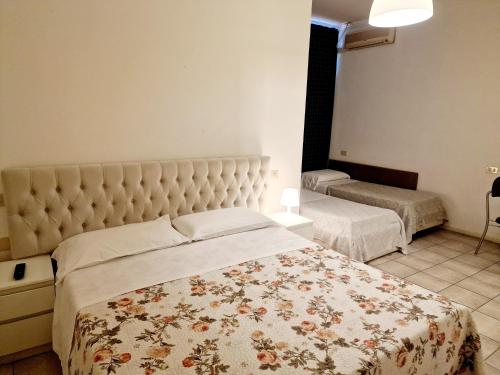 a bedroom with a large bed with a floral blanket at Hotel Firenze 2000 in Florence