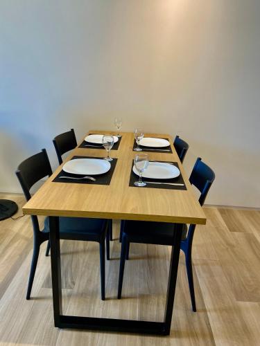 a wooden table with chairs and wine glasses on it at Praia de Piratininga Apartamento Vista Para o Mar in Niterói