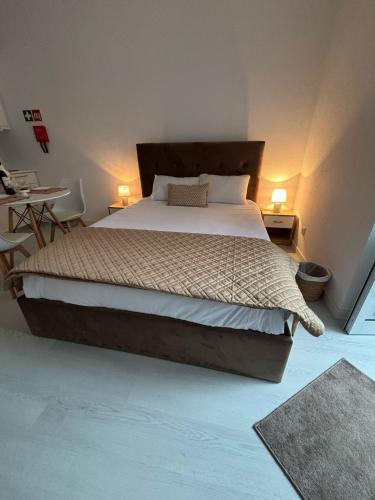 a bedroom with a large bed and a desk at Casa da Praça I in Vila Nova