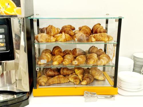 a display case filled with croissants and other pastries at Hotel Firenze 2000 in Florence