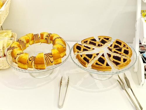 two cakes in glass bowls on a shelf at Hotel Firenze 2000 in Florence