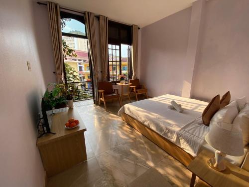 a bedroom with a bed and a balcony with a table at Lavande Hue Homestay in Hue