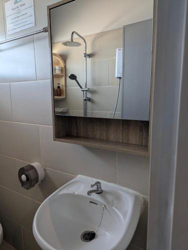 a bathroom with a white sink and a mirror at Moonhut Bungalows in Mae Nam