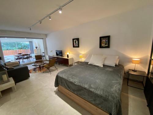 une chambre avec un lit et un salon dans l'établissement Studio rénové avec terrasse, à 100m de la plage à Arcachon, parking privé inclus - FR-1-374-99, à Arcachon