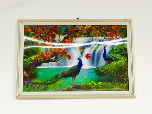 a painting of three peacocks in front of a waterfall at NMK Trinco Holiday Inn in Trincomalee