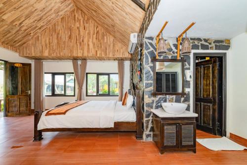 a bedroom with a bed and a sink in a room at Mai Chau Sunrise Village in Mai Chau