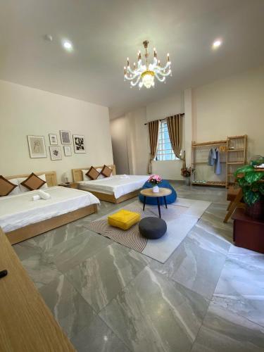 a large room with two beds and a chandelier at Lavande Hue Homestay in Hue