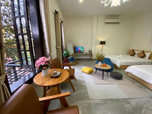 a living room with a bed and a couch and tables at Lavande Hue Homestay in Hue