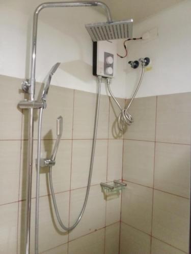 a shower in a bathroom with a shower head at The SPLENDOR comfortable living by Awsom Phil in Manila