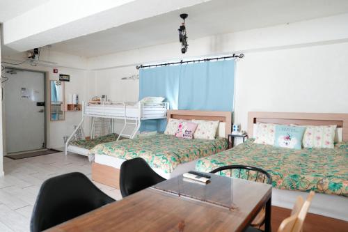 a room with two beds and a table and chairs at Residence Unicorn in Seoul