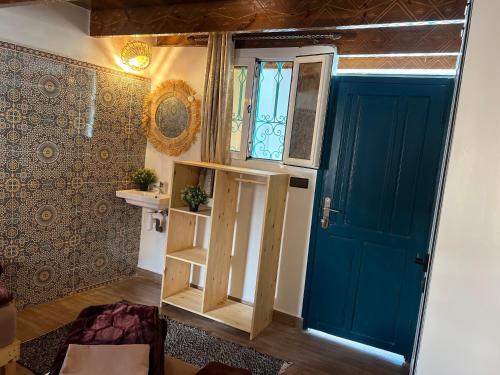 Habitación con puerta azul y ventana en Zand Surf Morocco, en Taghazout