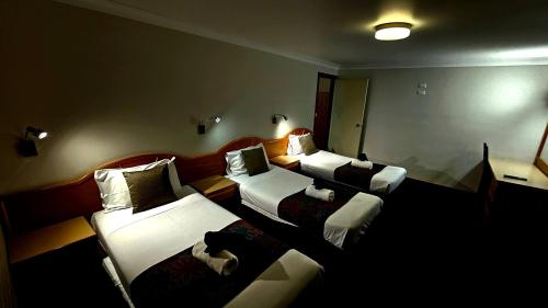 Postel nebo postele na pokoji v ubytování Hilltops Retreat Motor Inn