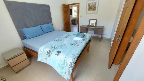 una camera da letto con un letto con un piumone blu di Corail - Holiday apartment a Grande Gaube