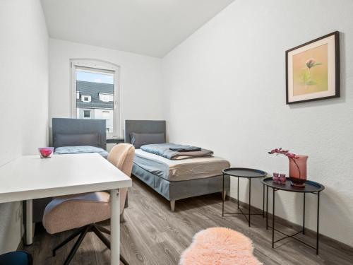 una habitación con dos camas y una mesa y sillas en Wohnung in zentraler Lage - Kostenlose Parkplätze, en Kassel
