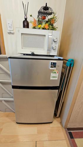 首尔Hongdae Guesthouse4 - 1min from Hongik Uni station Exit #1的冰箱上方设有微波炉
