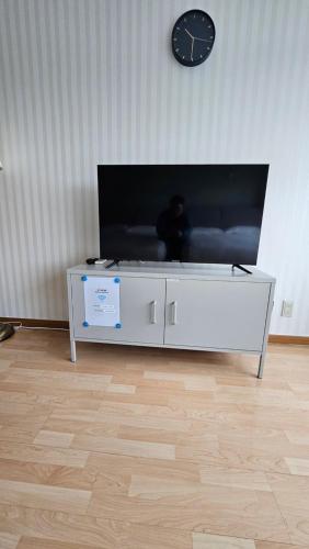 a white coffee table in a living room with a clock at Hongdae Guesthouse4 - 1min from Hongik Uni station Exit #1 in Seoul