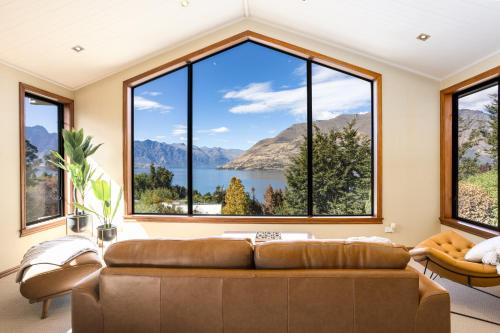 a living room with a large window overlooking a lake at Spectacular LAKE View in Queenstown