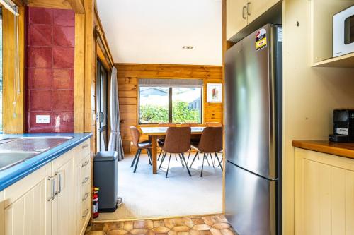 a kitchen with a table and a refrigerator at Spectacular LAKE View in Queenstown